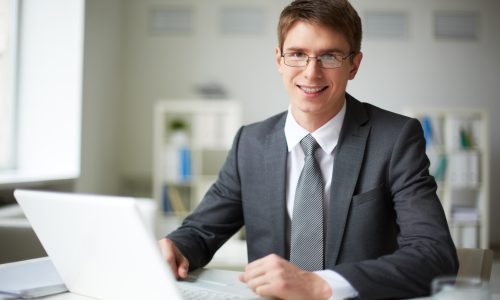 male-executive-with-glasses-typing-laptop-min